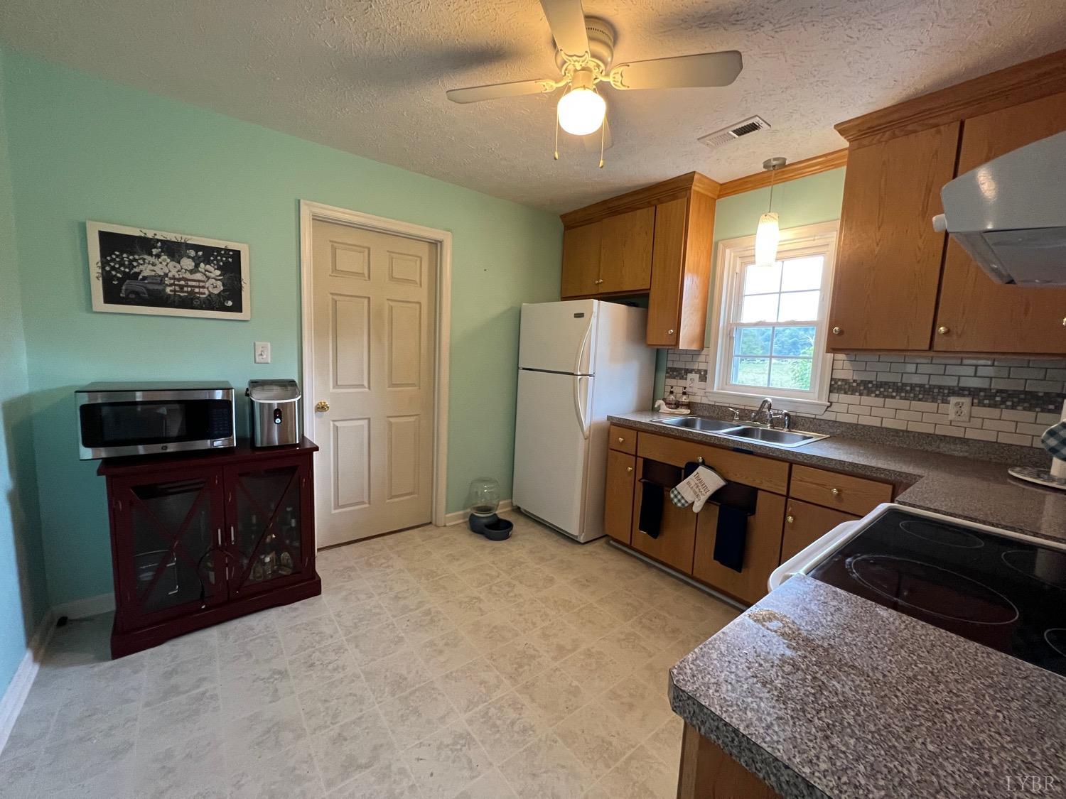 857 Woodson Road Roseland, VA 22967 - Photo 9 of 31 a kitchen with a refrigerator and a stove top oven