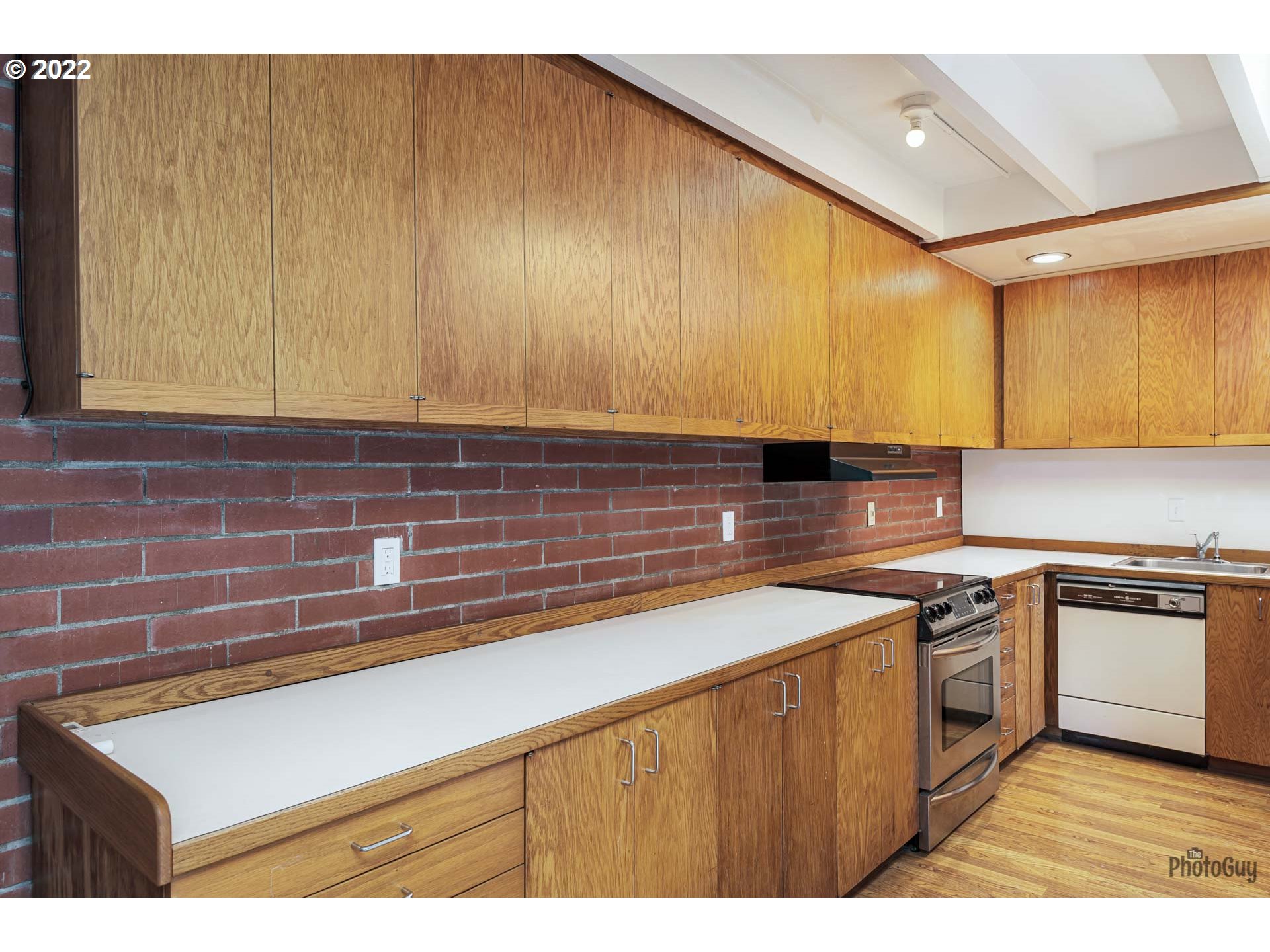110 High Street Eugene, OR 97401 - Photo 8 of 25 a kitchen with stainless steel appliances a sink dishwasher a stove a refrigerator with wooden cabinets