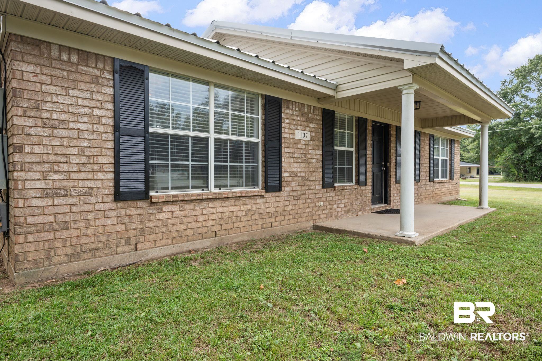 1107 North Oak Street Loxley, AL 36551 - Photo 25 of 40 Rear view of house featuring a lawn