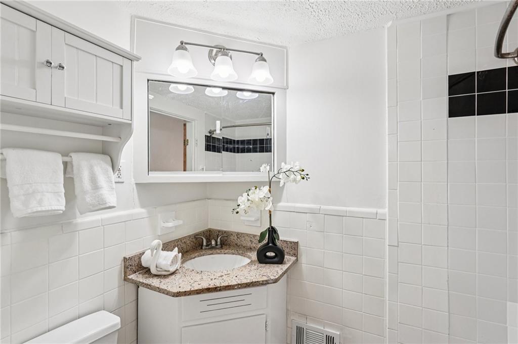 2226 Whites Mill Road Decatur, GA 30032 - Photo 26 of 51 a bathroom with a granite countertop sink a toilet and a mirror