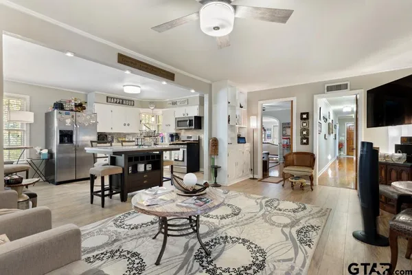 a living room with furniture kitchen view and a flat screen tv