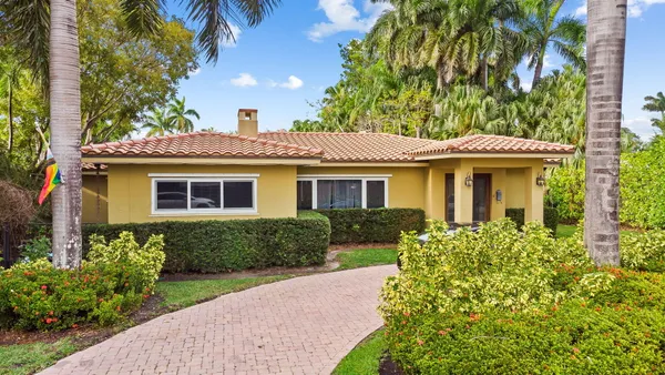 a front view of a house with a garden