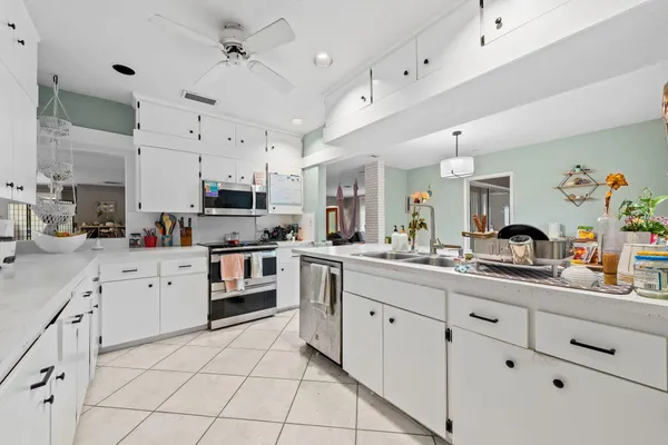 a kitchen with cabinets and chairs