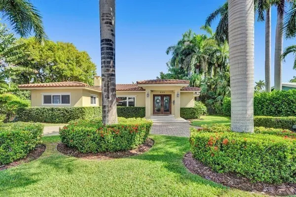a front view of a house with a yard and potted plants
