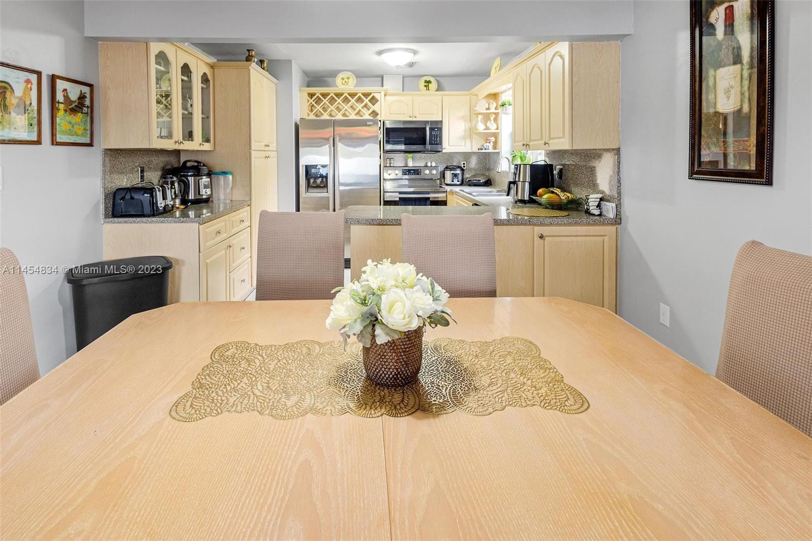 Tamiami Miami, FL 33182 - Photo 1 of 47 a kitchen with a refrigerator a sink dishwasher a dining table and chairs with wooden floor