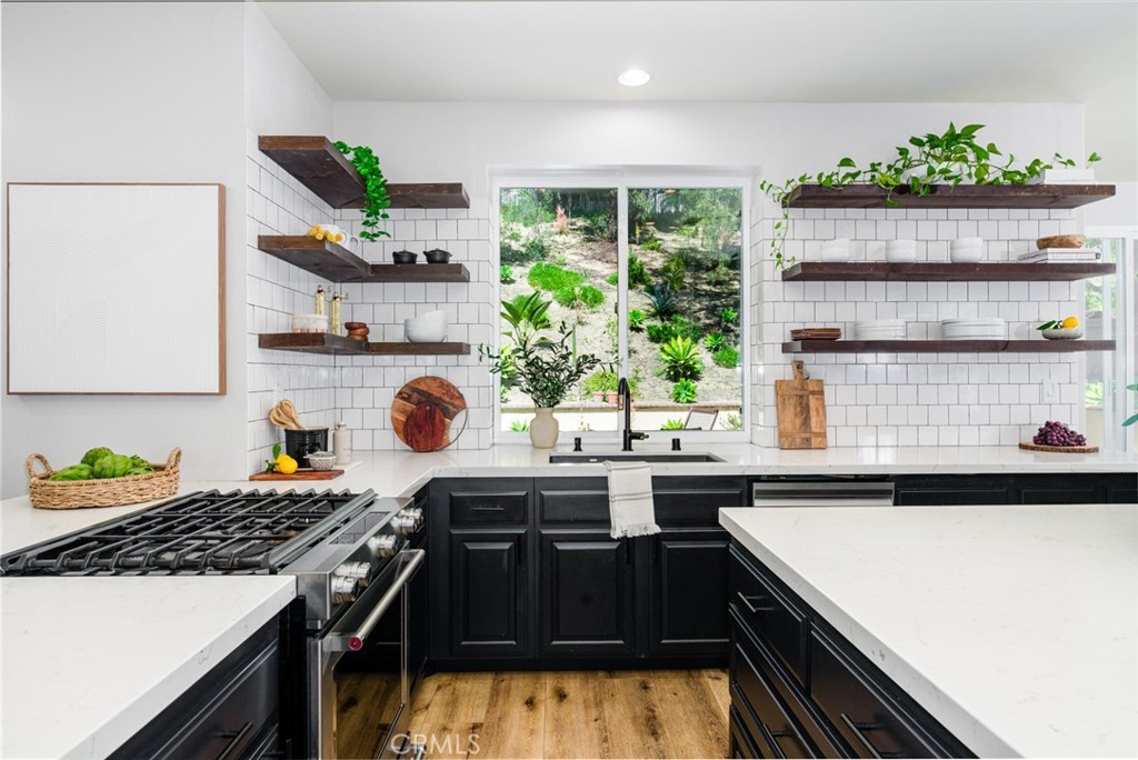 a kitchen with kitchen island granite countertop stainless steel appliances a sink stove and window