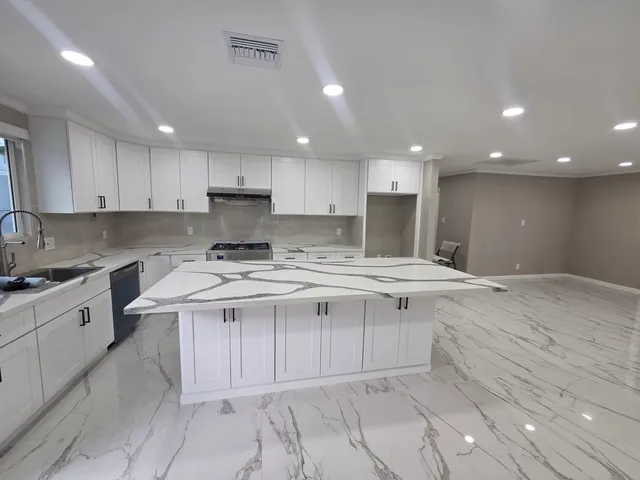 a large kitchen with kitchen island a sink stainless steel appliances and cabinets
