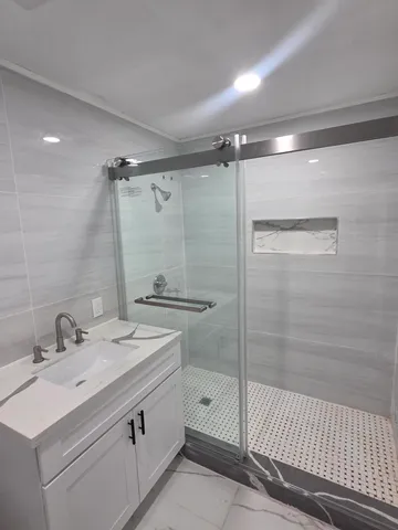 a bathroom with a sink a toilet and shower
