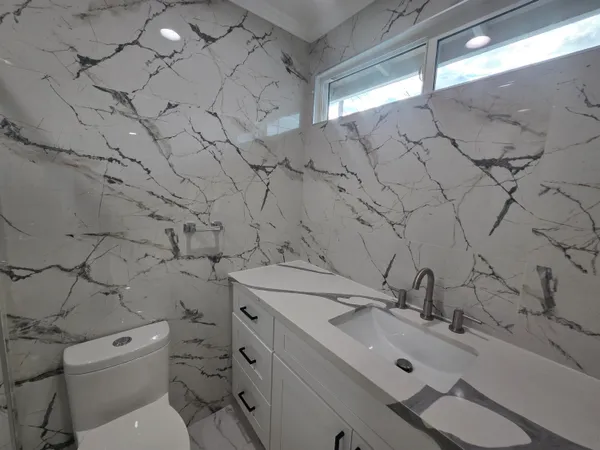 a bathroom with a sink mirror vanity and toilet
