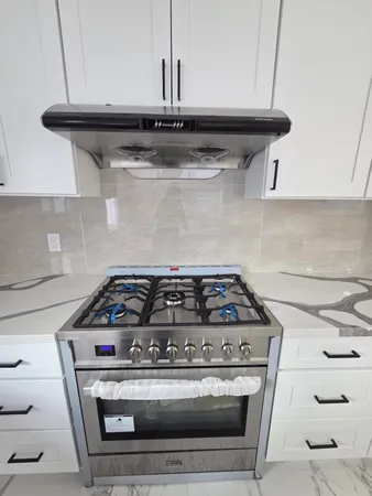 a stove top oven sitting inside of a kitchen
