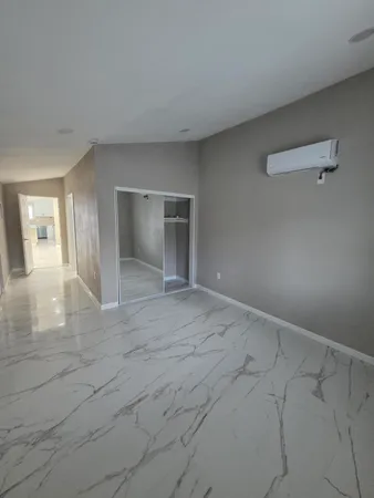 a view of a big room with wooden floor and bathroom