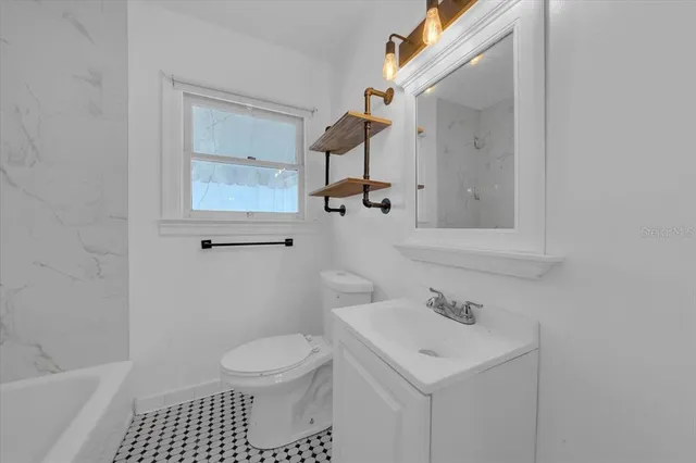 a bathroom with a sink toilet and a mirror