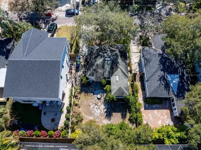 an aerial view of a house with a yard and large trees