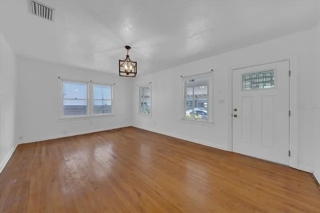 wooden floor in an empty room with a window