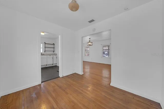 a view of empty room with wooden floor