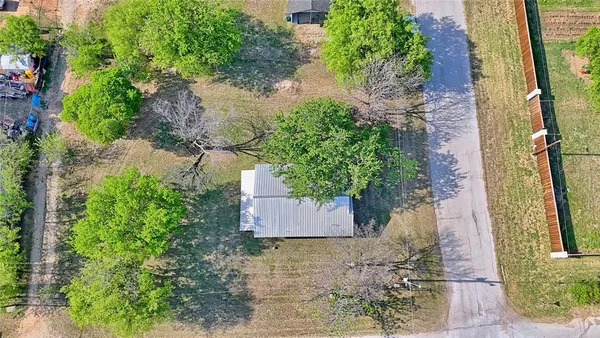an aerial view of a house with a yard and large tree