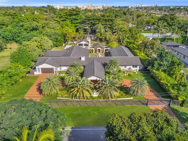 an aerial view of residential houses with outdoor space and trees