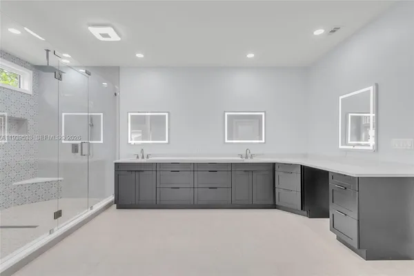 a spacious bathroom with double vanity sink and mirror