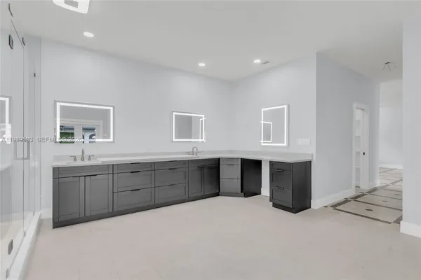 a bathroom with a double vanity sink a large mirror and shower