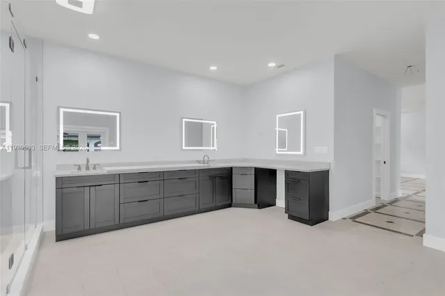a bathroom with a double vanity sink a large mirror and shower