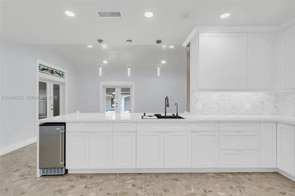 a view of a kitchen with kitchen island a sink wooden floor and outdoor space