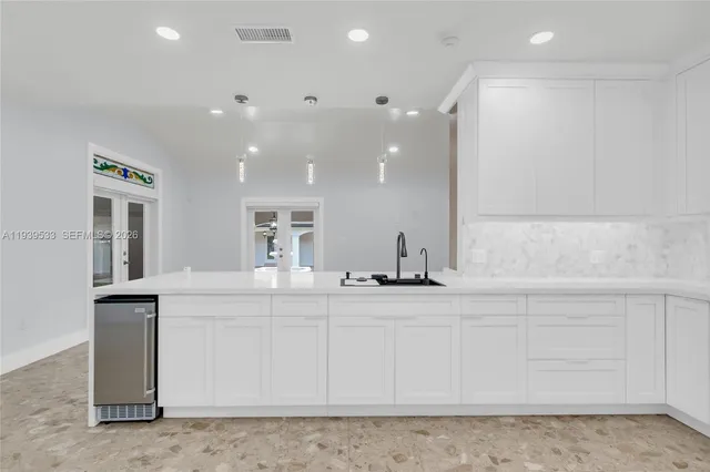 a view of a kitchen with kitchen island a sink wooden floor and outdoor space