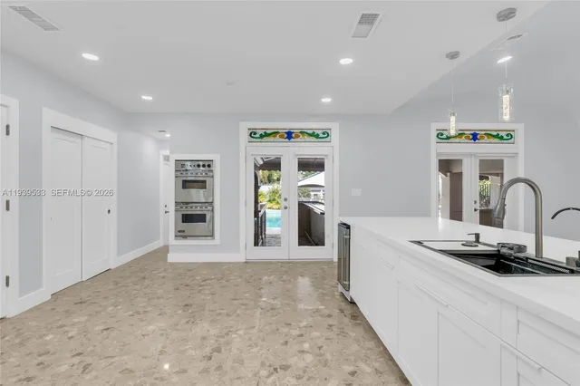 a large kitchen with a large counter top appliances and a living room view