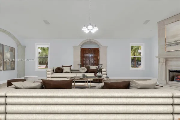 a living room with furniture chandelier and a fireplace