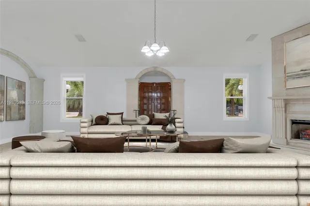 a living room with furniture chandelier and a fireplace