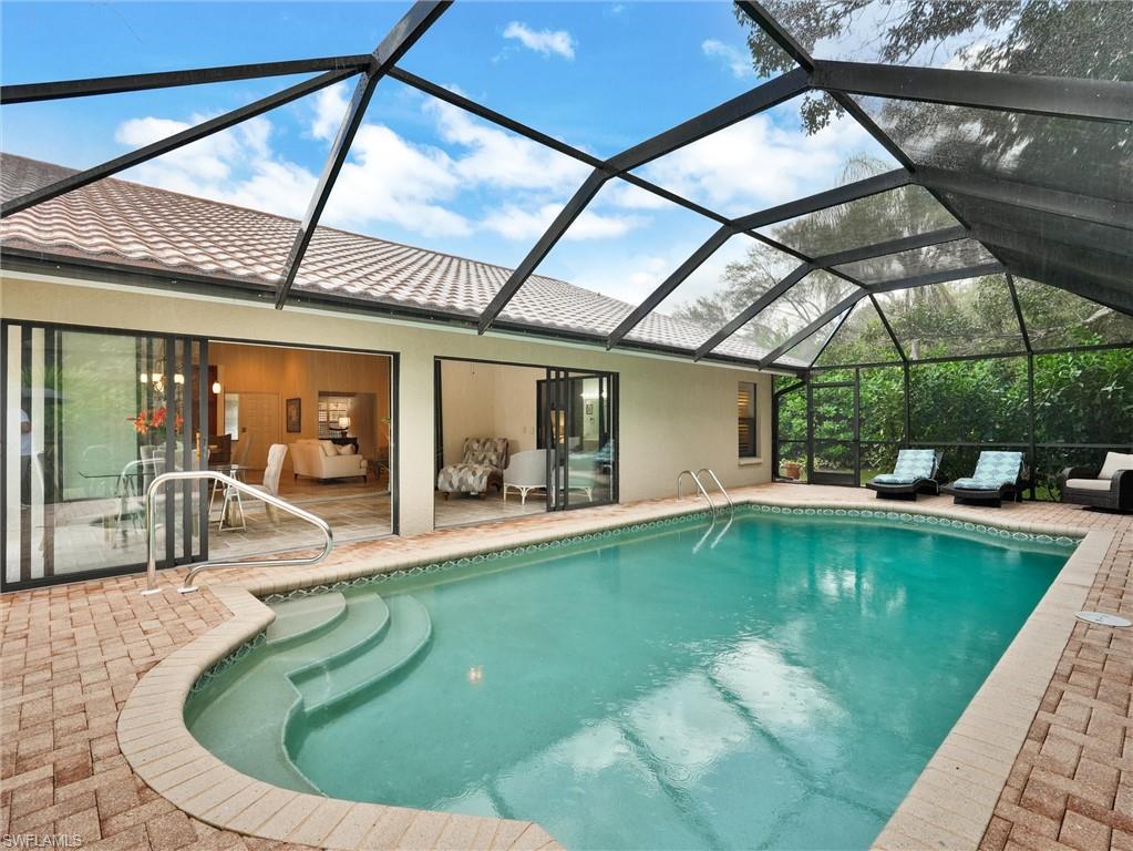 241 St James Way Naples, FL 34104 - Photo 3 of 34 Outdoor pool with a sunroom, a patio area, and glass enclosure