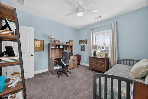 a view of a workspace with furniture and a window