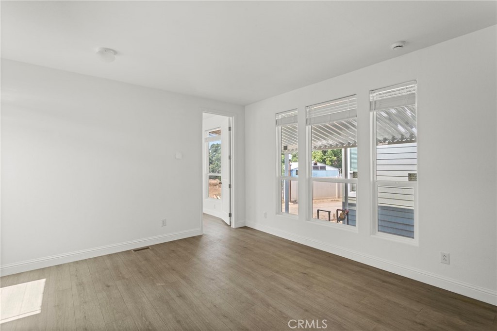 22113 Grand Terrace Road, Unit 7 Grand Terrace, CA 92313 - Photo 5 of 16 an empty room with wooden floor and windows
