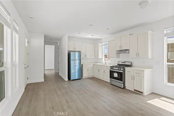 a kitchen with stainless steel appliances a refrigerator sink and stove