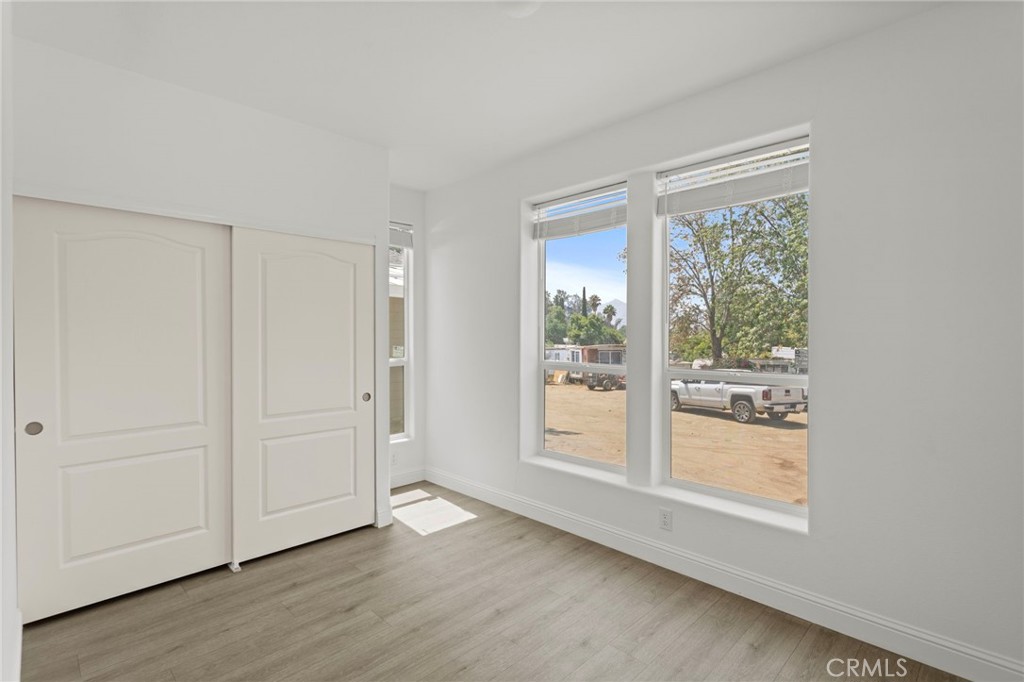 22113 Grand Terrace Road, Unit 7 Grand Terrace, CA 92313 - Photo 9 of 16 an empty room with wooden floor and windows