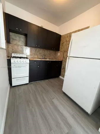a kitchen with a refrigerator and a stove