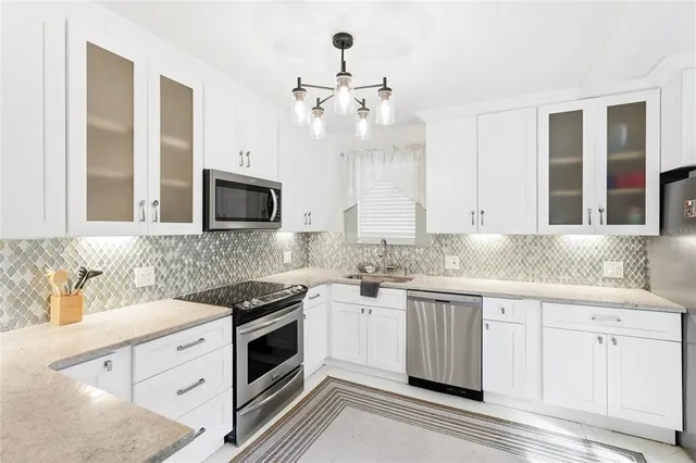 a kitchen with granite countertop white cabinets and white appliances