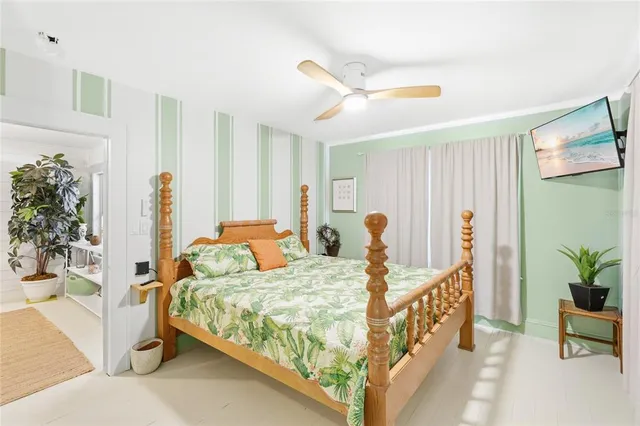 a bedroom with bed and a potted plant