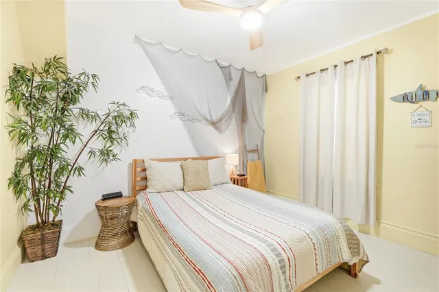 a bedroom with a bed and a potted plant