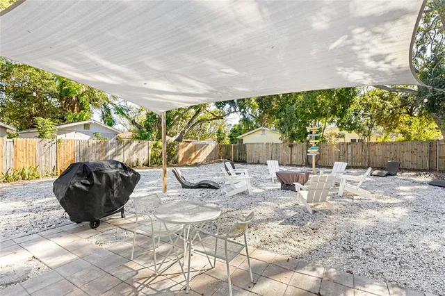 a view of a patio with table and chairs potted plants with wooden fence