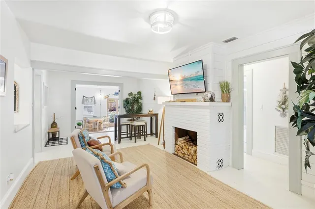 a living room with furniture a fireplace and a potted plant