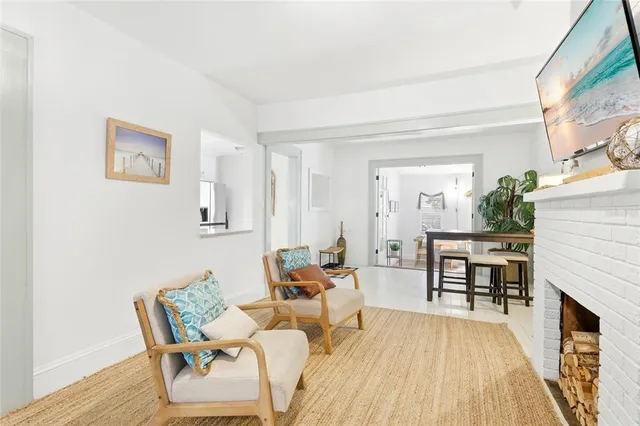 a living room with furniture a fireplace and wooden floor