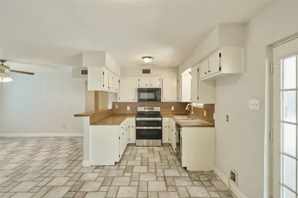 a kitchen with stainless steel appliances a stove a sink and a refrigerator