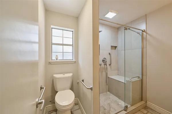 a bathroom with a toilet and a shower