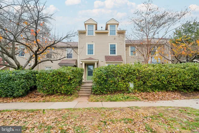 a view of a white house with a yard and plants