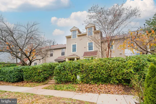 a view of a white house next to a road and yard