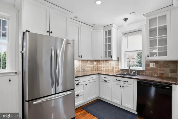 a kitchen with a refrigerator sink and cabinets
