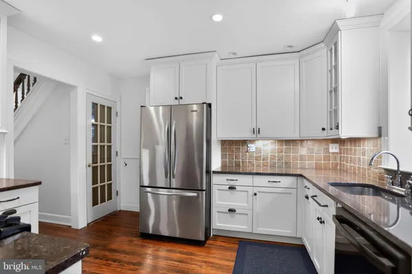 a kitchen with granite countertop a refrigerator stove and sink