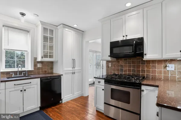 a kitchen with granite countertop white cabinets and white appliances