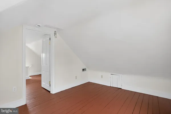 a view of a room that has wooden floor and windows in a room