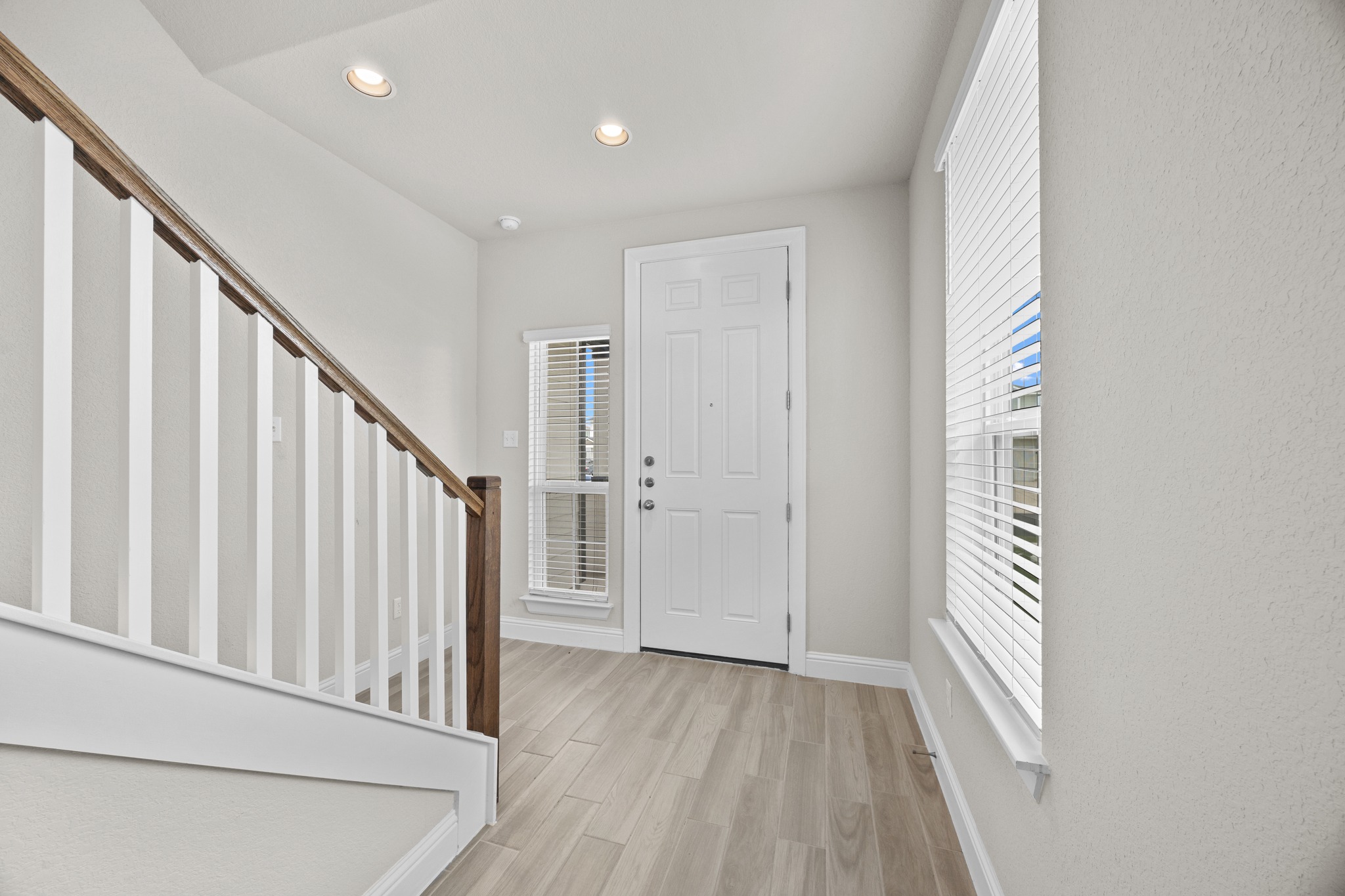 213 Graver Street Georgetown, TX 78626 - Photo 19 of 33 A welcoming entry, with a robust wooden staircase, offers bright, naturally illuminated interiors.